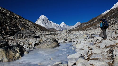 Rear view of person on snowcapped mountains against sky