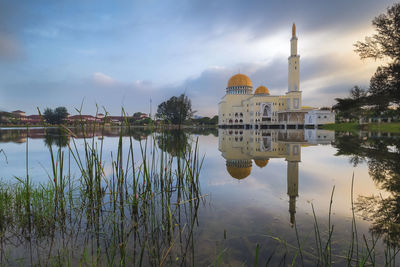 Panoramic view of lake by temple against sky