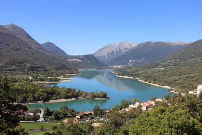 Panoramic view of lake and mountains against clear blue sky