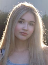 Portrait of young woman in blond hair on sunny day