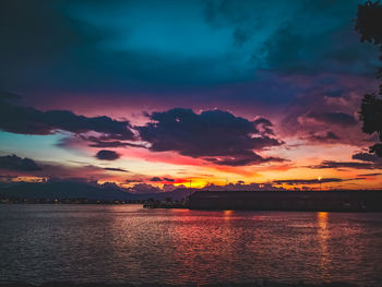 Scenic view of sea against dramatic sky during sunset