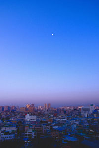 High angle view of buildings against clear blue sky