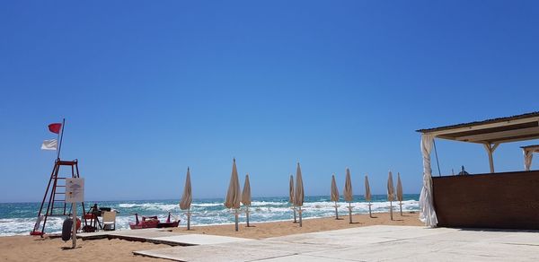 Scenic view of beach against clear blue sky