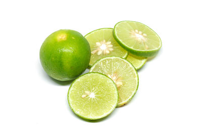 Close-up of green fruits against white background