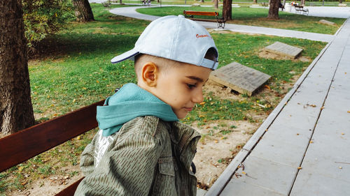 Side view of boy on bench at park