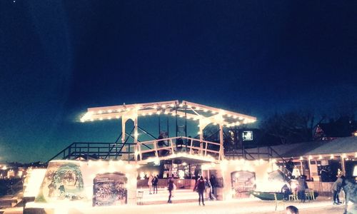 People in front of illuminated building at night