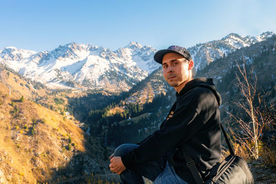 Young man in mountains against sky