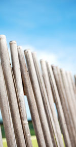 Low angle view of wooden fence against blue sky