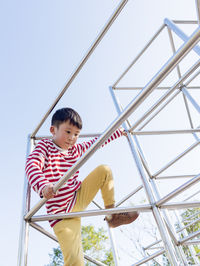 A young boy climbs up in a public playground