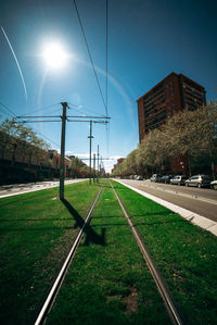 Railroad track amidst grass against sky