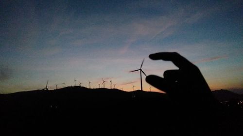 Silhouette person photographing against sky during sunset