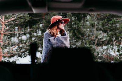 Woman wearing sunglasses standing in park during winter