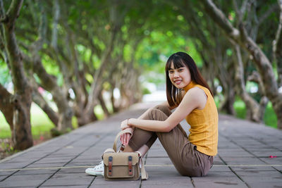 Portrait of smiling young woman sitting outdoors