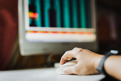 Cropped hand of man using pc computer