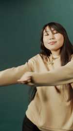Young woman gesturing against colored background