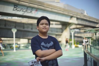 Portrait of boy standing against bridges