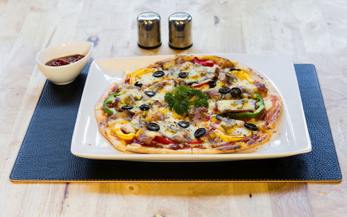 High angle view of pizza served on table