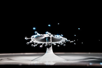 Close-up of illuminated water splashing against black background