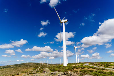 Low angle view of windmill on field against sky