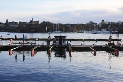 Sailboats in river with city in background