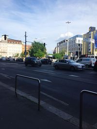 Cars on road against sky in city