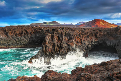 Panoramic shot of rocks in sea against sky