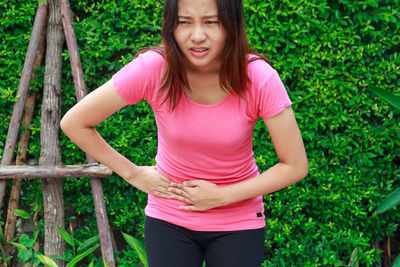 Woman suffering from stomachache while standing outdoors