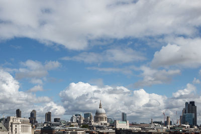 View of cityscape against cloudy sky