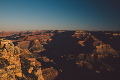 Scenic view of cliff against clear sky at grand canyon national park during sunset