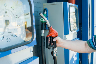 Cropped image of man holding fuel pump at gas station