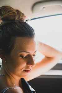 Smiling young woman sitting in car