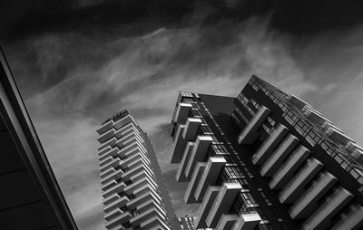 Low angle view of modern building against cloudy sky