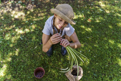 High angle view of senior woman holding fresh green grass