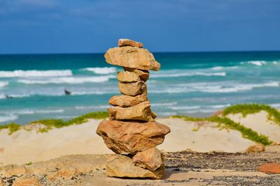 Stack of rocks on beach against sky