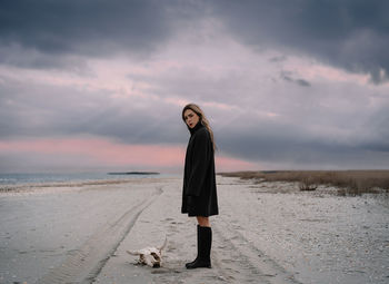 Young woman in raincoat on the beach 