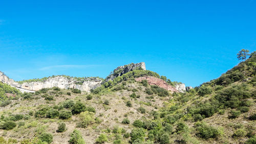 Low angle view of mountain against clear blue sky