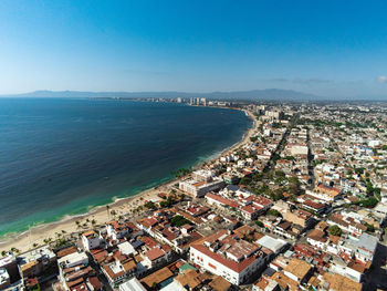 High angle view of city by sea against sky