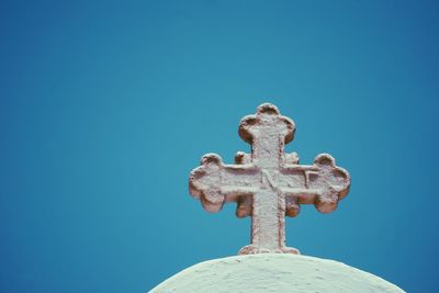 Low angle view of cross on dome against clear blue sky