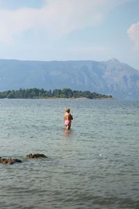 Man in sea against sky