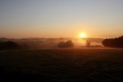 Scenic view of field against sky during sunset