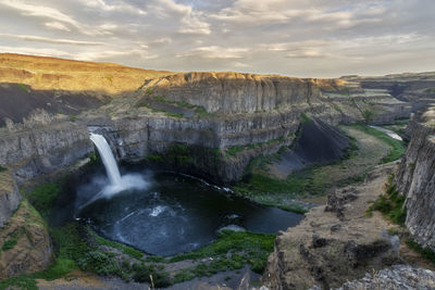 Scenic view of waterfall against sky