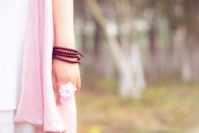 Cropped image of woman holding pink flowers