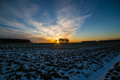 Scenic view of snow covered landscape at sunset