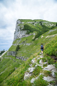 Rear view of man on rock against sky