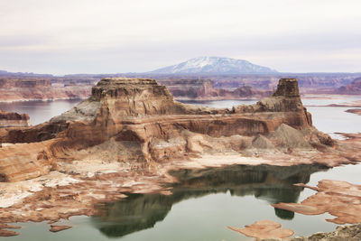 Rock formations in lake against sky