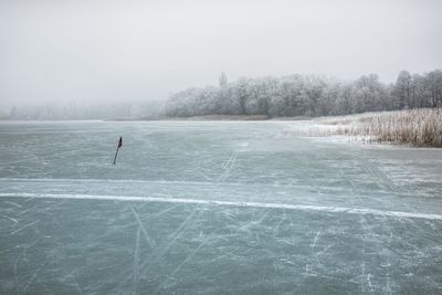Scenic view of lake against sky during winter