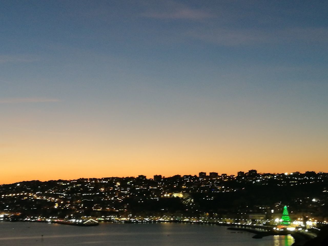 ILLUMINATED CITYSCAPE AGAINST SKY AT SUNSET