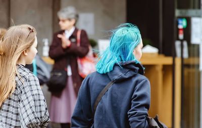 Rear view of people standing against blurred background