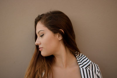 Close-up of young woman against gray background