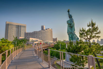 Statue in city against clear sky